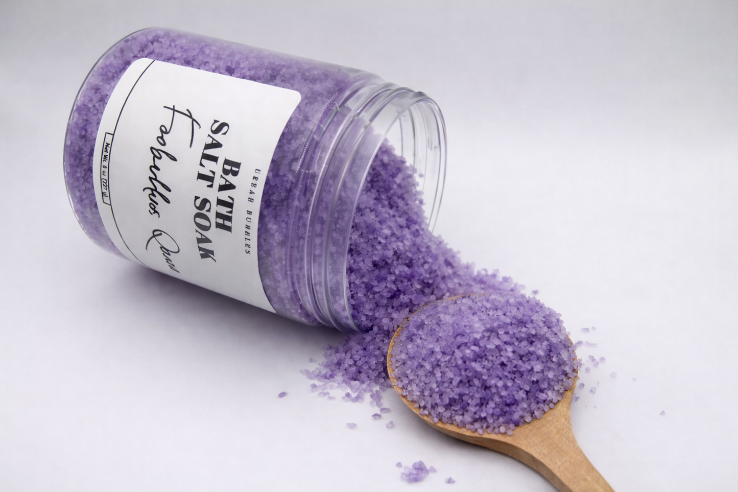 Purple bath salt with a wooden spoon on a white background