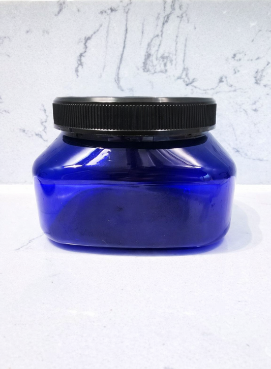 Blue container with black lid on a white marble background
