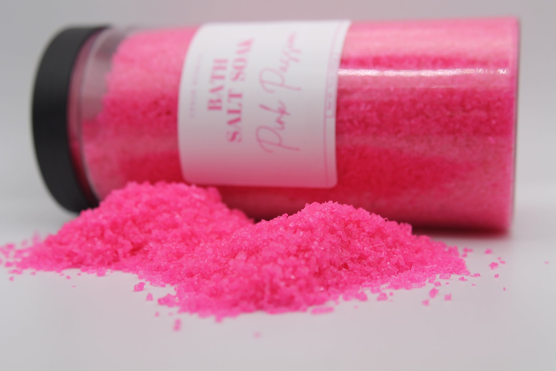 Pink bath salt with a visible label on a white background
